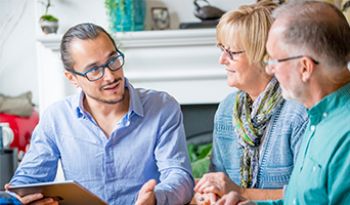 A Scorecard assessor in conversation with an older couple  